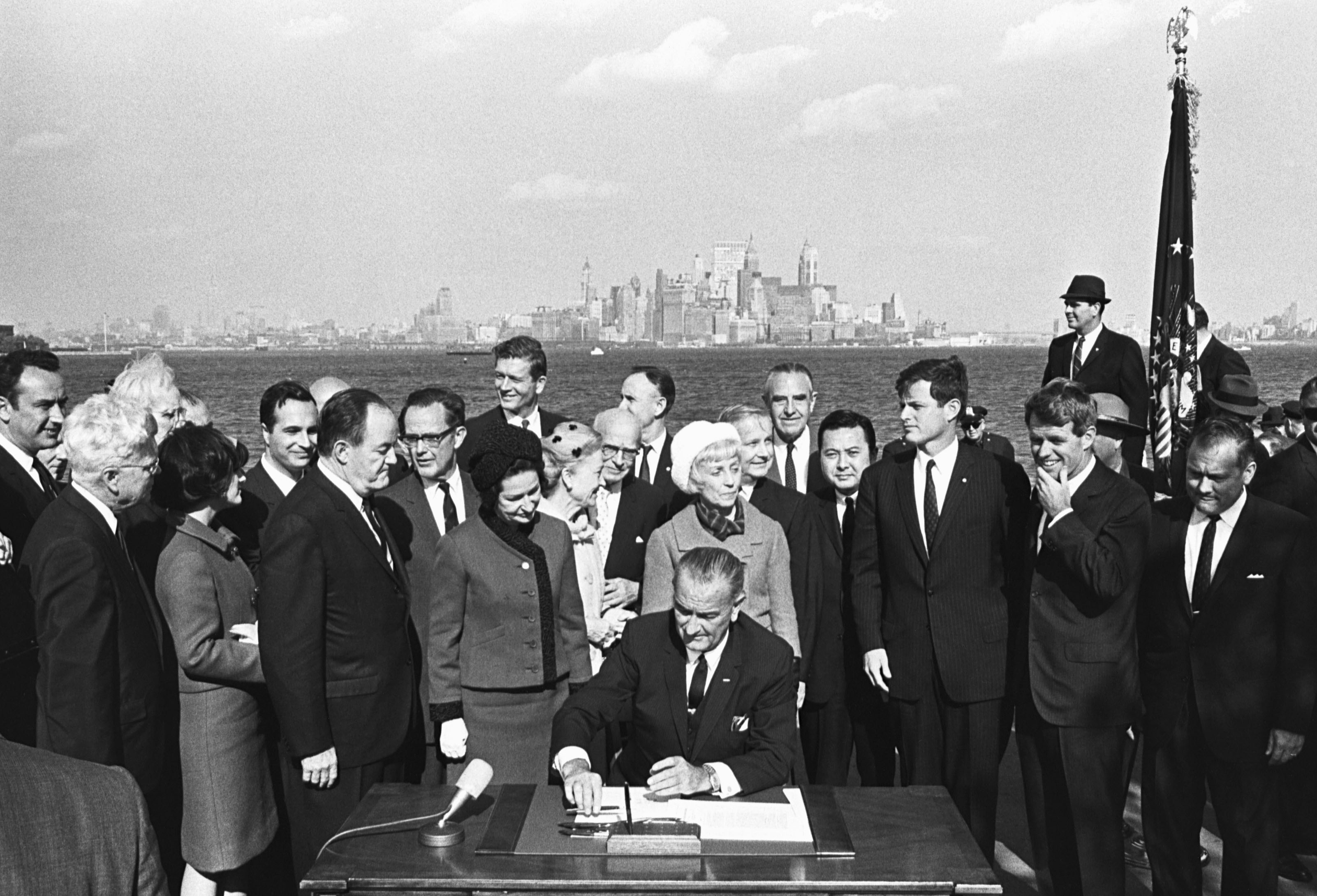 President Lyndon B. Johnson signs the Immigration Bill of 1965 on Liberty Island in New York Harbor.