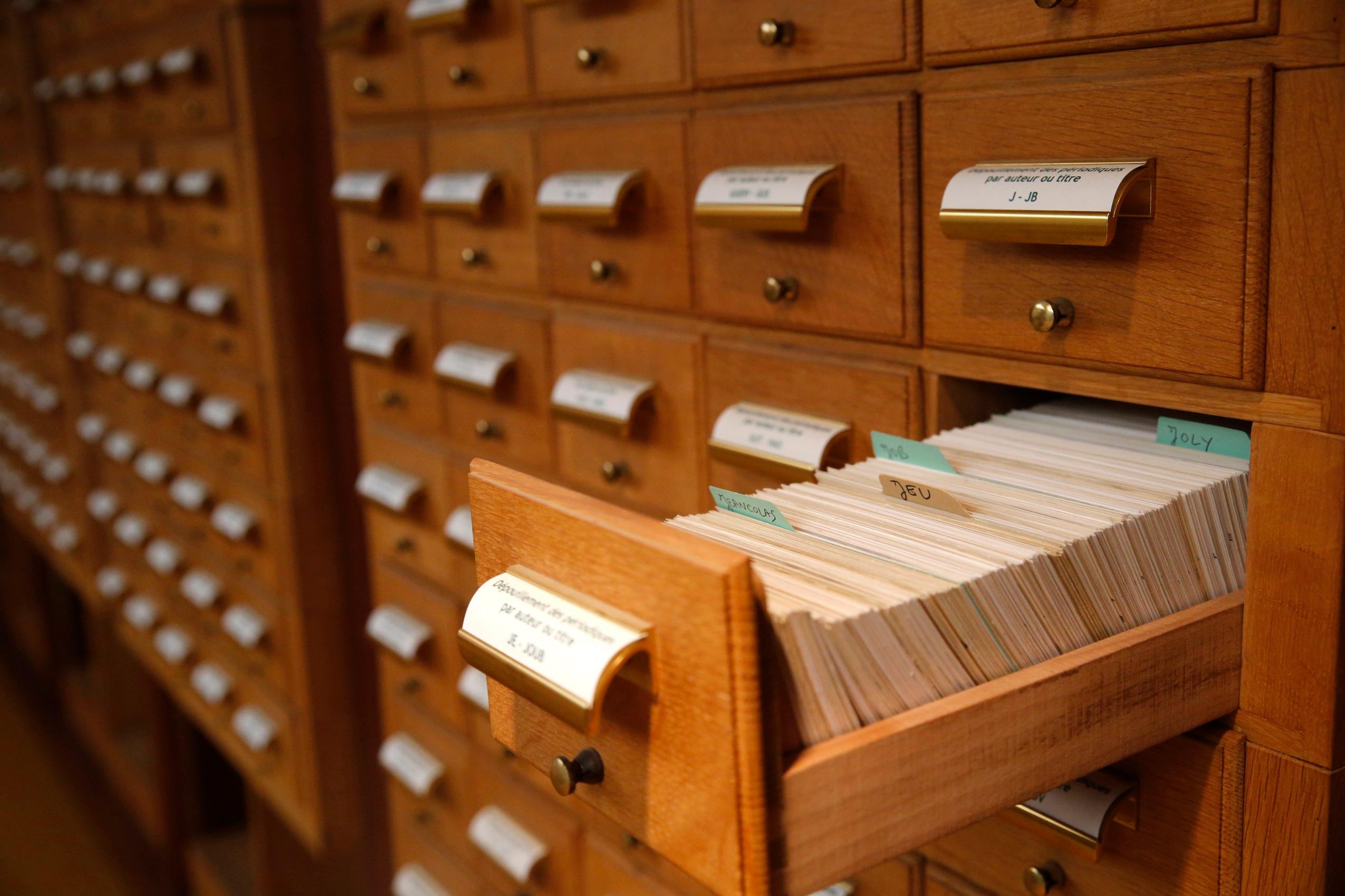 A card catalogue with a drawer open, showing the index cards inside