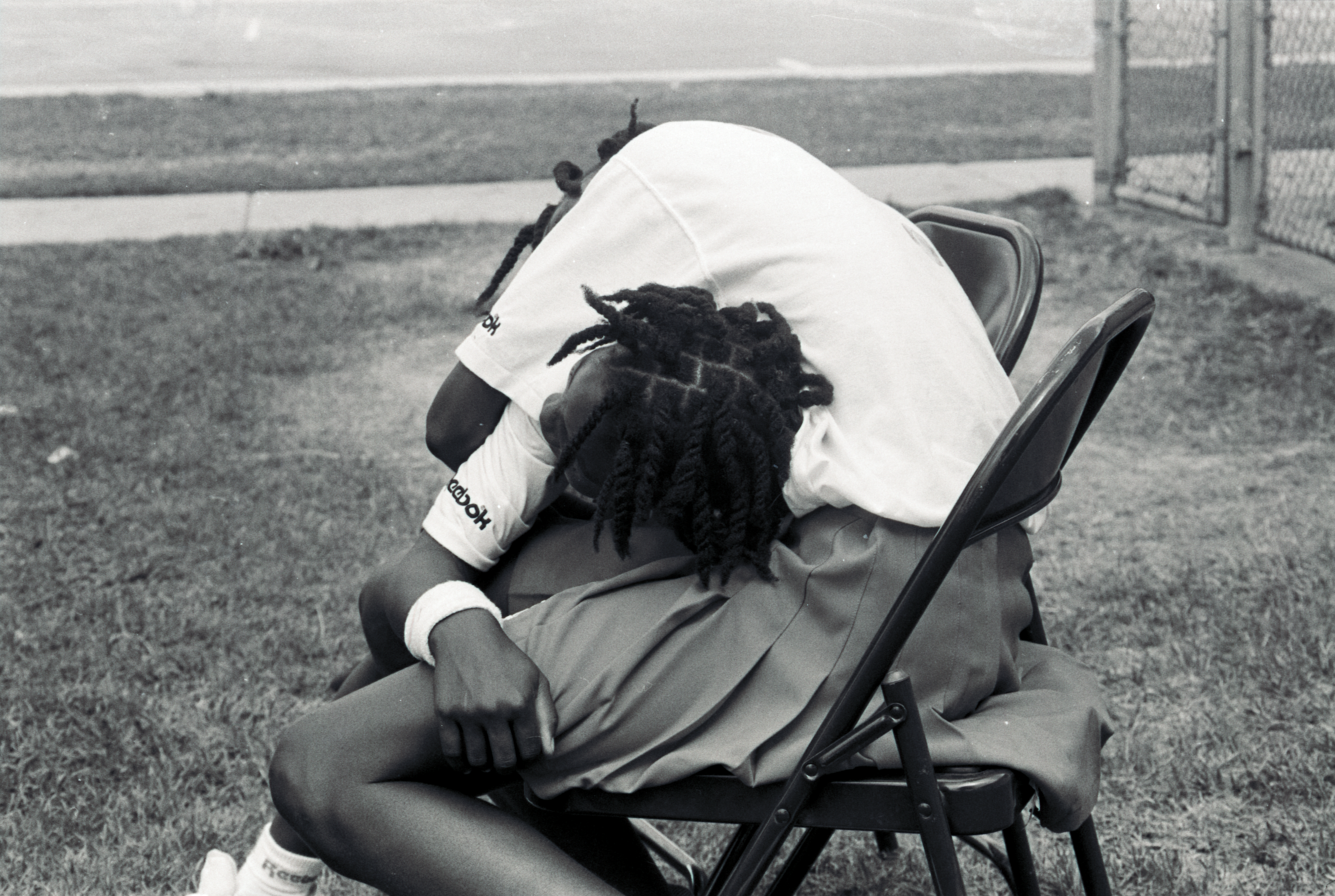 Serena leans on Venus' lap, while Venus leans over Serena's back to embrace her