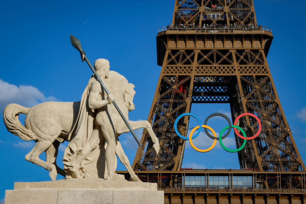 Olympic rings are seen on the Eiffel Tower near the restored statue of "Cavalier Arabe" on the Pont d'Iéna bridge in Paris on July 4, 2024, ahead of the upcoming Paris 2024 Olympic Games. 