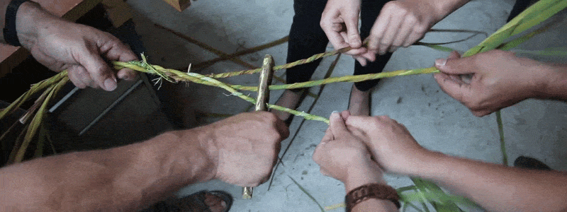 gif of hands working together to create rope from cattail fibers