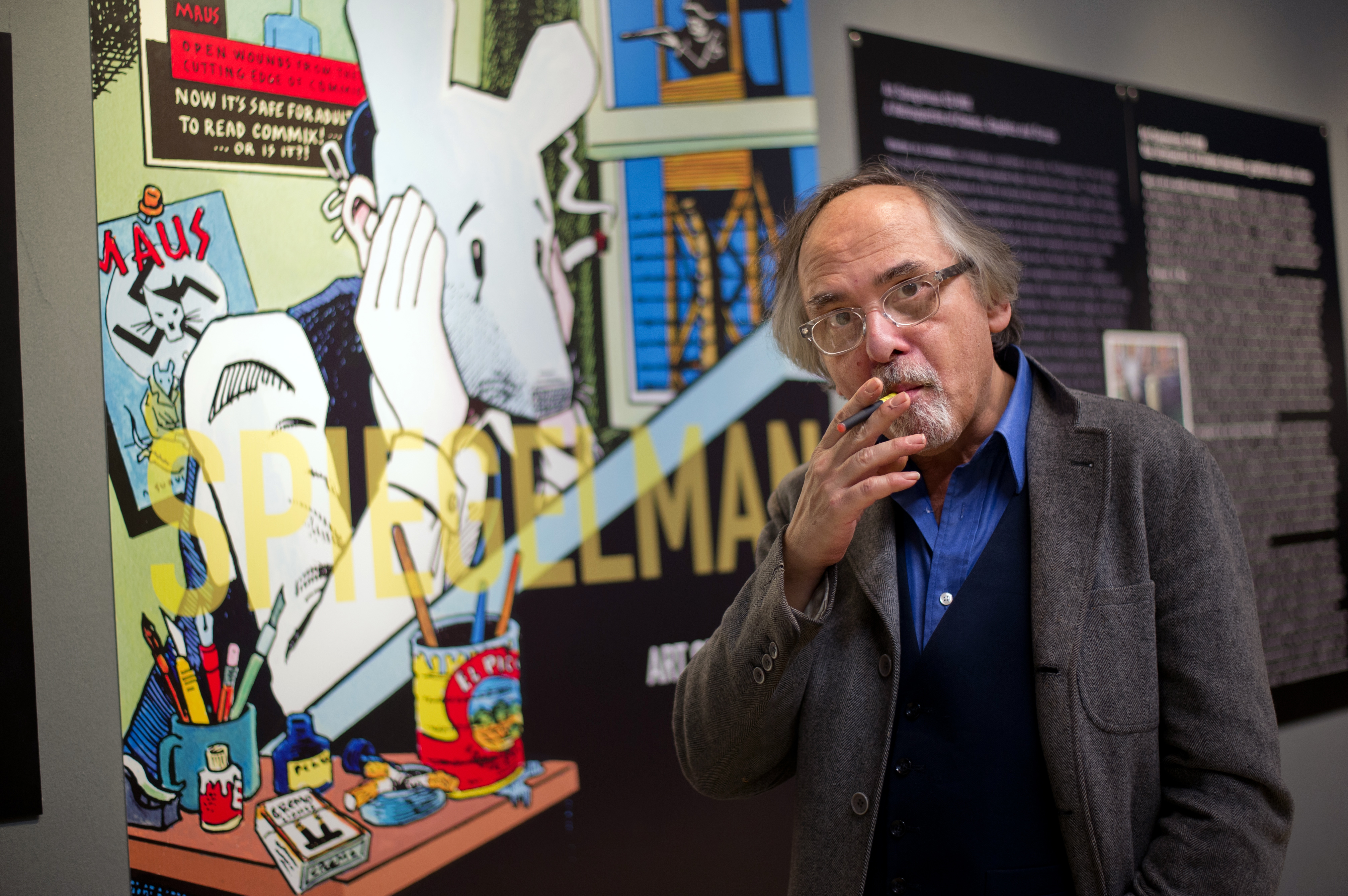 Art Spiegelman poses next to an illustration from his seminal comic memoir Maus on March 20, 2012, prior to an exhibition of his work.