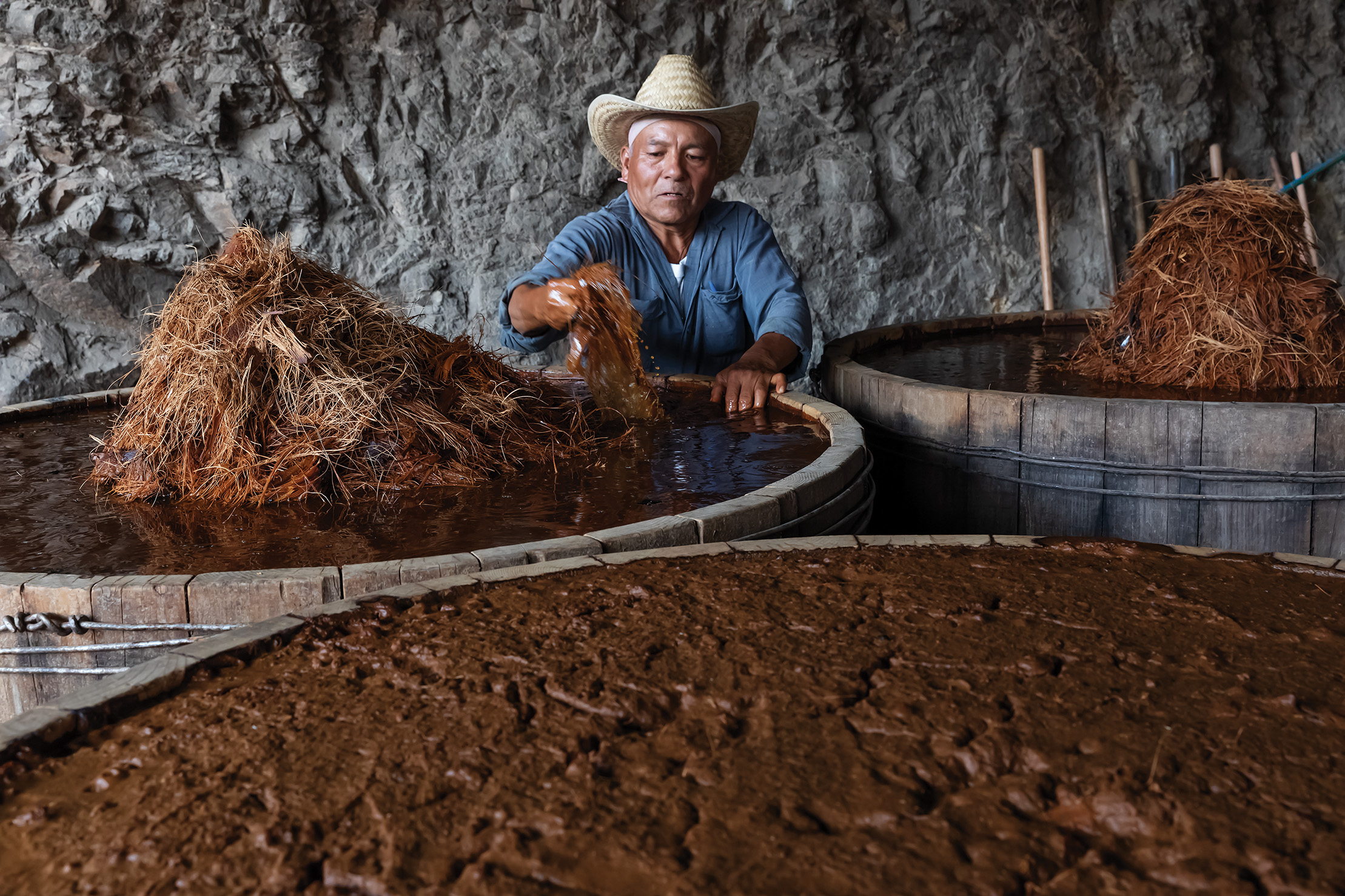 José Santiago of Palenque Don Lencho, in San Pablo Guilá village, with wooden vats of fermenting agave prior to distillation